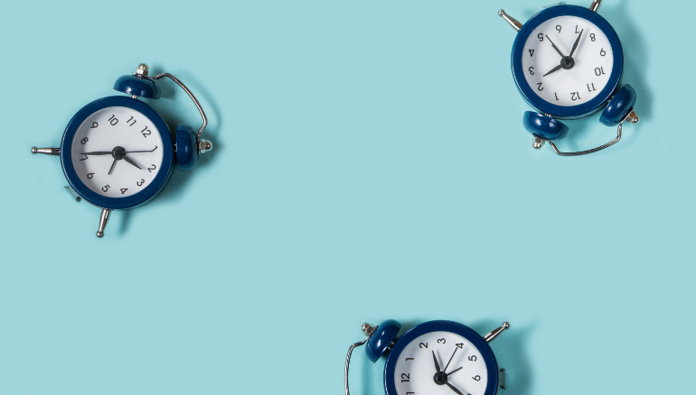 Dark blue alarm clocks on light blue background