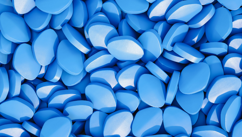 Close-up photo of hundreds of diamond-shaped blue pills
