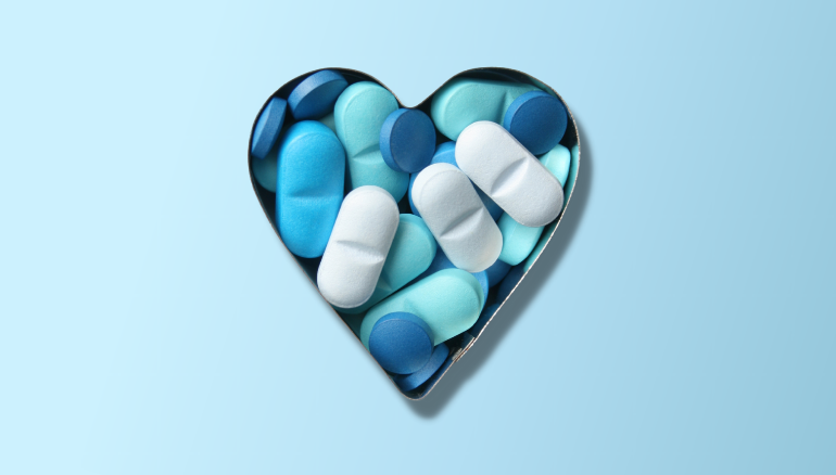 Heart-shaped tin of blue pills on blue gradient background