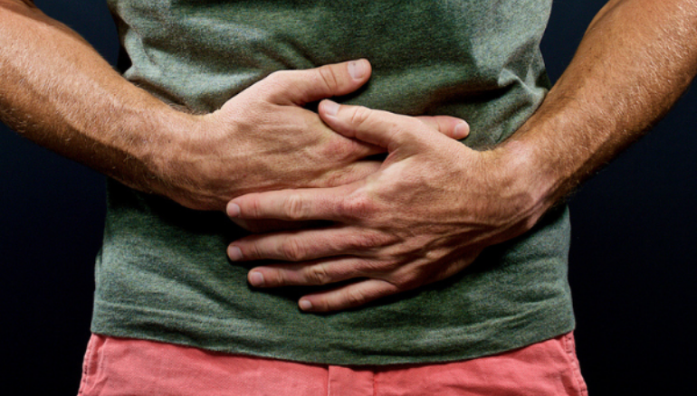 man holding stomach with both hands