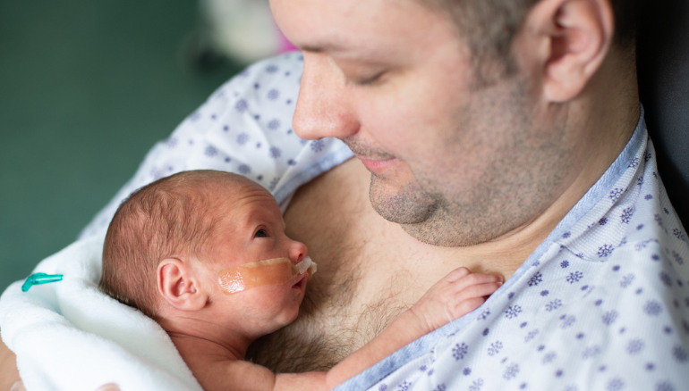 man holds premature baby