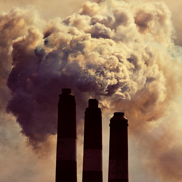 Photo of polluted sky with chimneys in diminishing heights in foreground